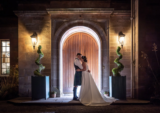 Bride and groom kiss outside main entrance